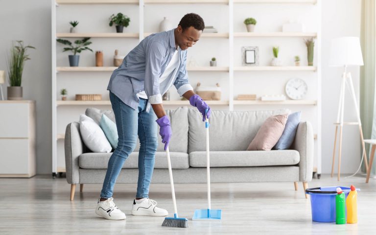 cheerful-black-guy-cleaning-living-room-holding-b-2021-09-04-02-50-46-utc.jpg